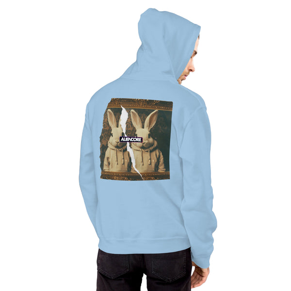 Person wearing a white hoodie with a logo on a light gray brick wall background