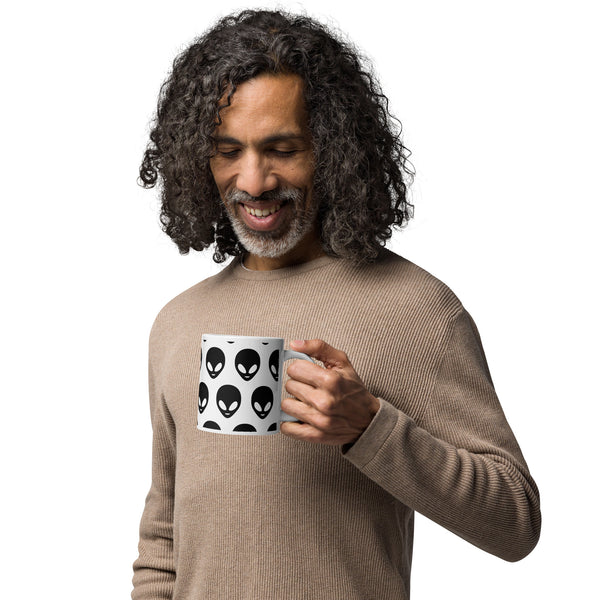 Man holding a mug with alien pattern design on a white background