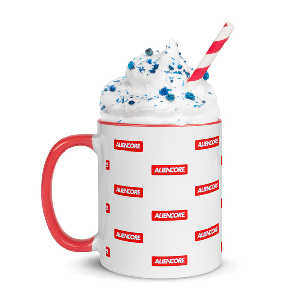 Mug with red handle and 'ALIENCORE' branding, filled with a white drink and blue sprinkles.