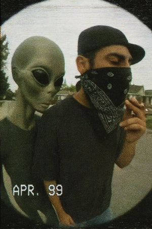 Person in alien costume and another person with bandana in a casual setting.