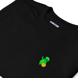 Black t-shirt with a small green alien design on a white background