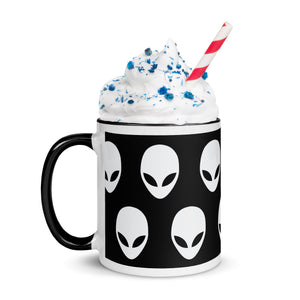 Mug with alien pattern filled with a milkshake and straw on a white background