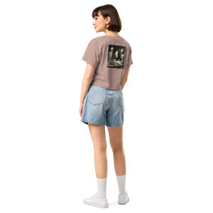 Person wearing a beige t-shirt with a graphic on the back and denim shorts on a white background