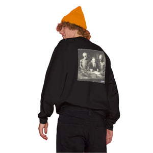 Person wearing a black sweatshirt with a graphic design on the back against a gradient background