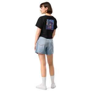 Person wearing a black t-shirt with a colorful design on the back and denim shorts on a white background