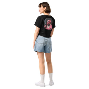 Person wearing a black t-shirt with a graphic design on the back and denim shorts on a white background