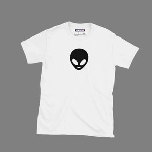 White t-shirt with black alien logo on a light gray surface with accessories around