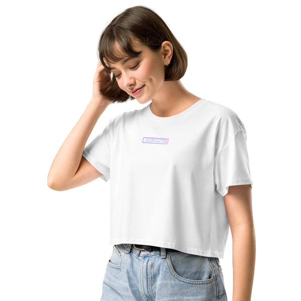 Woman wearing a white t-shirt with a small logo on a white background