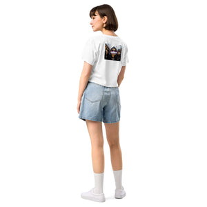 Person wearing a white t-shirt with a graphic design and denim shorts on a white background